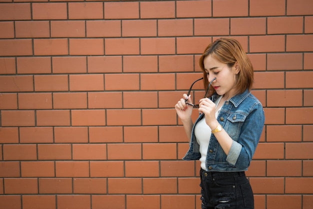 Porträt asiatisches sexy Hipster-Mädchen auf Backsteinmauer-Hintergrundmode-Konzeptthailand-Menschen