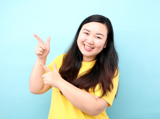 Porträt-Asien-Frauen mit einem Finger, auf einem blauen Hintergrund im Studio.