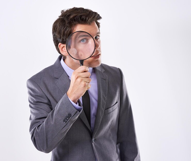 Foto porträt auge und geschäftsmann mit vergrößerungsglas untersuchung und prüfung in einem unternehmen auf weißem studio-hintergrund gesicht männlicher angestellter und pi mit compliance- und fairtrade-beweise oder informationen