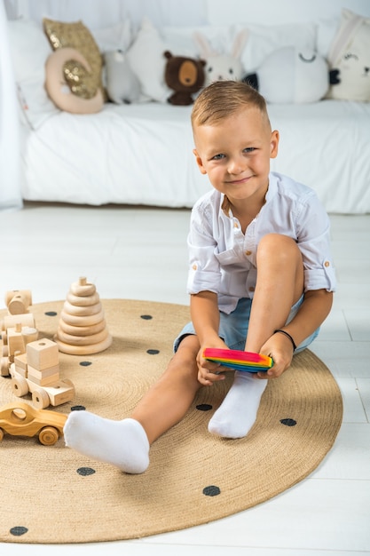 Porträt blonder Junge mit Pop-It-Sinnesspielzeug verschiedene Formen