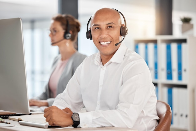 Porträt-Callcenter und Kundendienstmitarbeiter im Büro am Schreibtisch mit einem Lächeln. Berater kontaktieren Sie uns oder männlicher Vertriebsmitarbeiter, Telemarketing oder CRM-Helpdesk oder Support-Mitarbeiterberatung am Arbeitsplatz