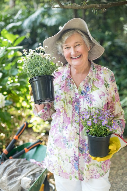 Porträt der älteren Frau Topfpflanzen halten