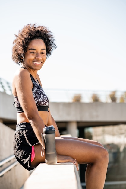 Porträt der Afro-Sportlerin, die sich nach dem Training im Freien entspannt