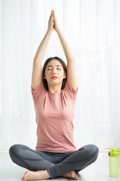 Porträt der asiatischen Frau, die Yoga zu Hause praktiziert