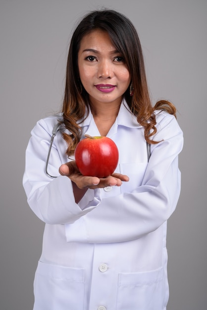 Porträt der asiatischen Ärztin, die Apfel hält