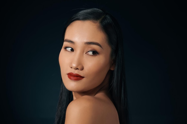 Porträt der attraktiven asiatischen Frau lokalisiert über schwarzem Hintergrund