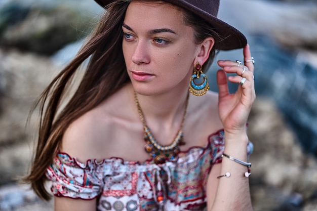 Porträt der attraktiven Boho-Chic-Brünettenfrau, die einen Filzhut und Schmuck trägt