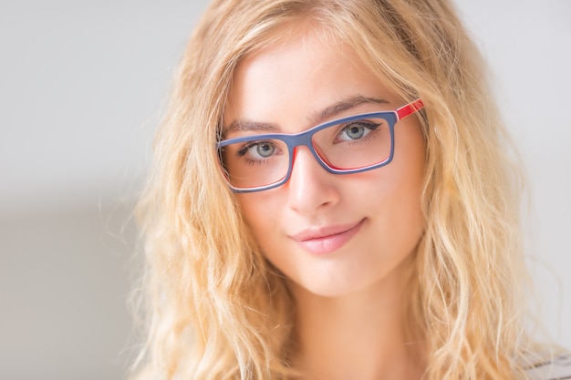 Porträt der blonden jungen Frau mit Brille.