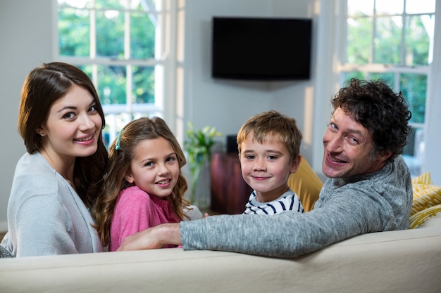 Porträt der Familie, die auf Sofa sitzt