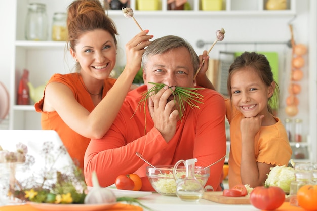 Porträt der Familie, die zusammen am Küchentisch kocht