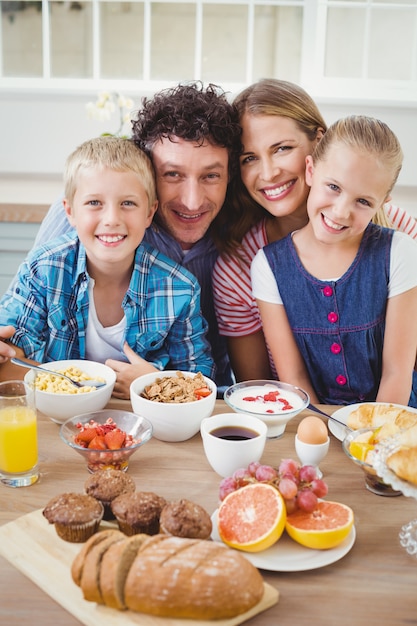 Foto porträt der familie lächelnd beim frühstücken