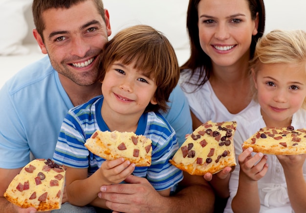 Porträt der Familie Pizza auf Sofa essend