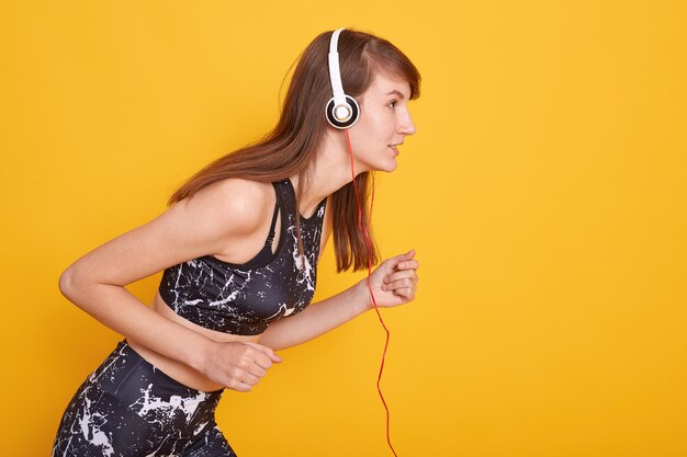 Porträt der fit und sportlichen jungen brünetten Frau, die sich auf das Laufen vorbereitet