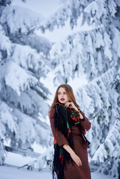 Porträt der Frau am Wintertag auf schneebedecktem Landschaftshintergrund