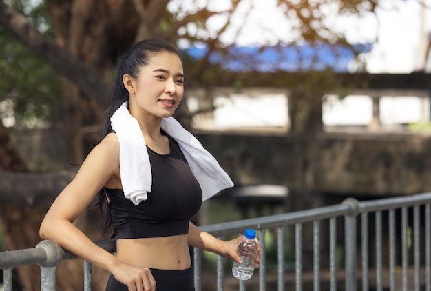 Porträt der Frau, die Pause vom Joggen, Sportlerin am Park macht