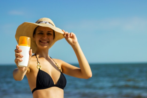 Porträt der Frau Hautpflege mit Lichtschutzlotion am Strand nehmend