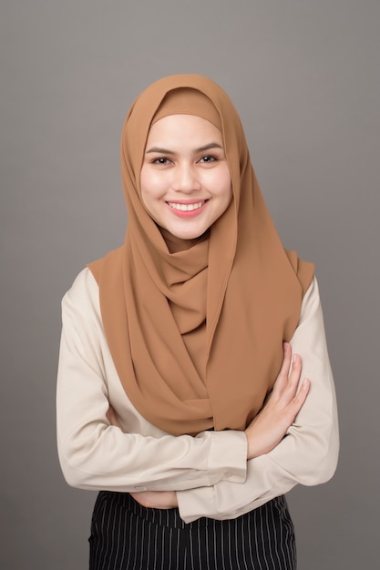 Porträt der Frau mit Hijab lächelt auf grau
