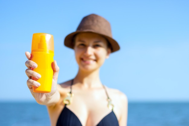 Porträt der Frau skincare mit Lichtschutzlotion am Strand nehmend