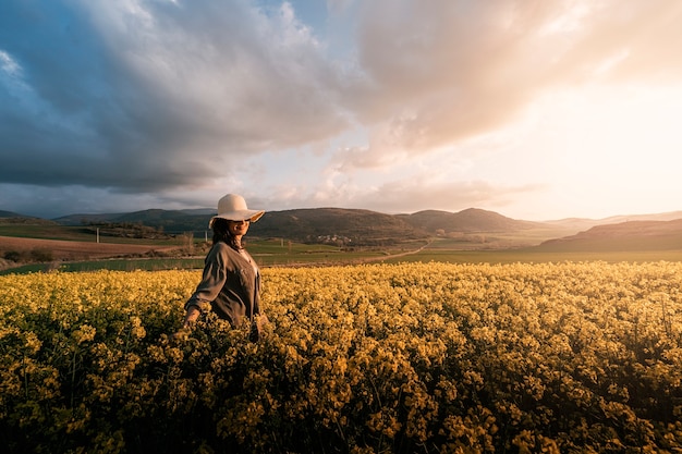 Porträt der Frau zu Fuß zwischen Blumen auf dem Lande. Melancholie-Konzept