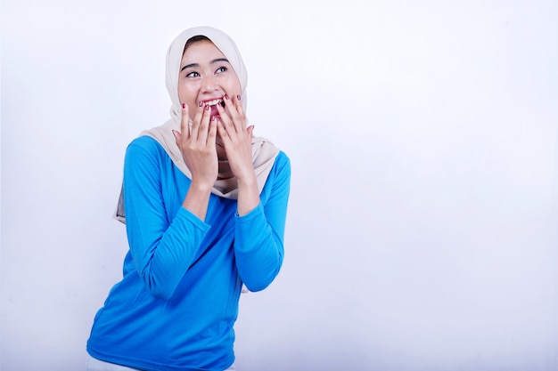 Porträt der freudigen jungen Frau mit dem blauen T-Shirt, das Hijab trägt und sich überrascht fühlt