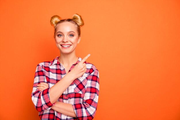 Porträt der fröhlichen jungen Frau gekleidet in einem karierten karierten Hemd lokalisiert auf Orange