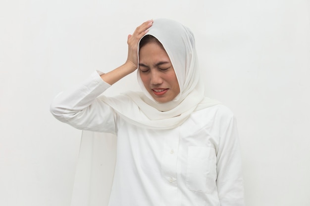 Porträt der gestressten kranken muslimischen Frau mit Kopfschmerzen kranke Frau leidet unter Schwindelschwindel Migräne-Kater-Gesundheitskonzept junge erwachsene asiatische Frau Modell