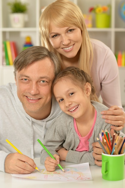 Porträt der glücklichen Familie, die zu Hause malt