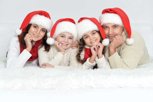 Porträt der glücklichen Familie in Weihnachtsmützen mit Geschenken