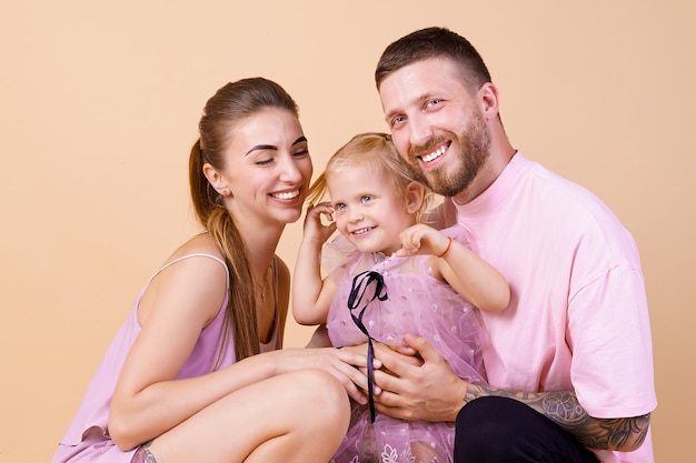 Porträt der glücklichen Familie Mama und Papa umarmt kleine süße Tochter Family Look