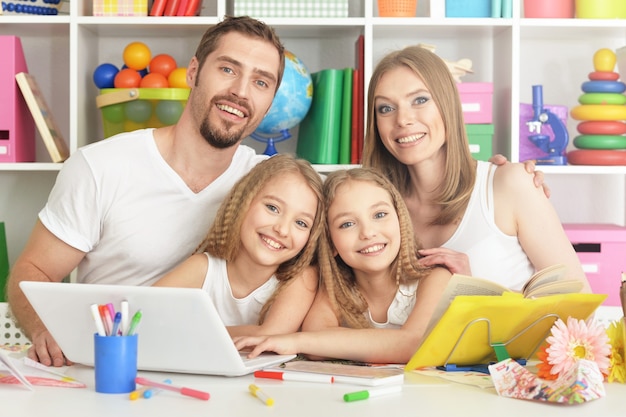 Porträt der glücklichen Familie mit Laptop zu Hause