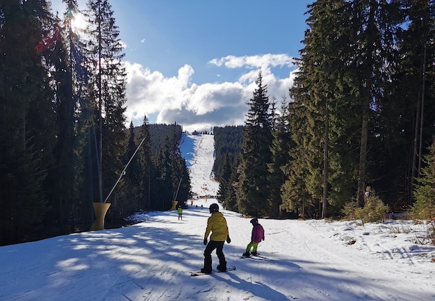 Porträt der glücklichen Familie mit Snowboards, die Kamera auf blauem Hintergrund betrachten