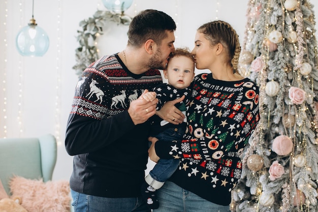 Porträt der glücklichen Familie von Vater, Mutter und kleinem, lockigem Sohn, die Weihnachten zusammen zu Hause feiern Silvester-Konzept