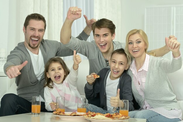 Porträt der glücklichen Familie zu Hause mit Pizza