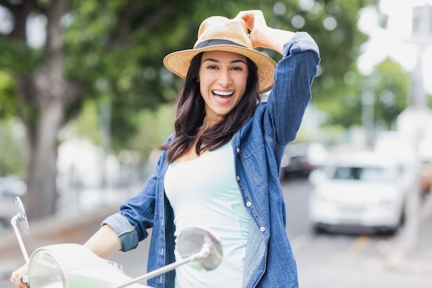 Porträt der glücklichen Frau auf Moped