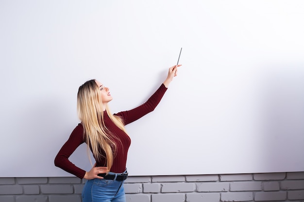 Foto porträt der glücklichen jungen geschäftsfrau frau nahe auf weißer wand