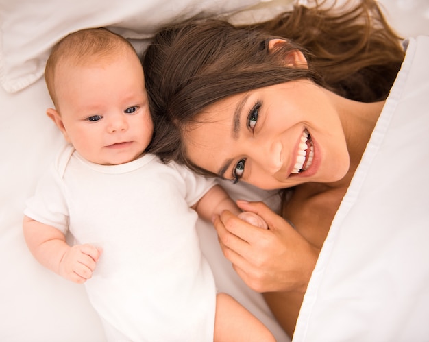 Porträt der glücklichen jungen Mutter mit einem Baby.