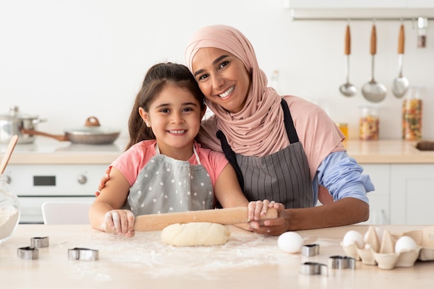 Porträt der glücklichen muslimischen Familie, Mutter und Tochter, die zusammen in der Küche backen