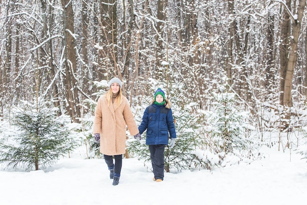 Porträt der glücklichen Mutter mit dem Kindersohn im Winter im Freien. Schneebedeckter Park. Alleinerziehend.