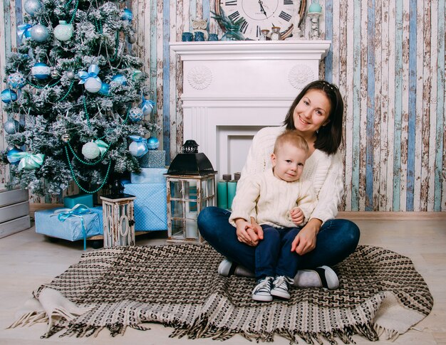 Porträt der glücklichen Mutter und des entzückenden kleinen Jungen zu Hause. Weihnachts-, Neujahrs-, Winter- und Ferienzeitkonzept. Familie.
