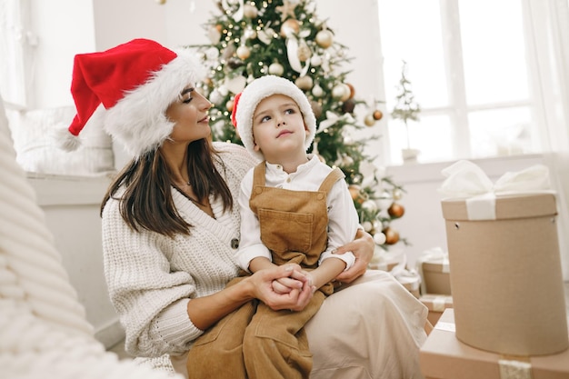 Porträt der glücklichen Mutter und ihres Sohnes feiern Weihnachten im festlich geschmückten Raum