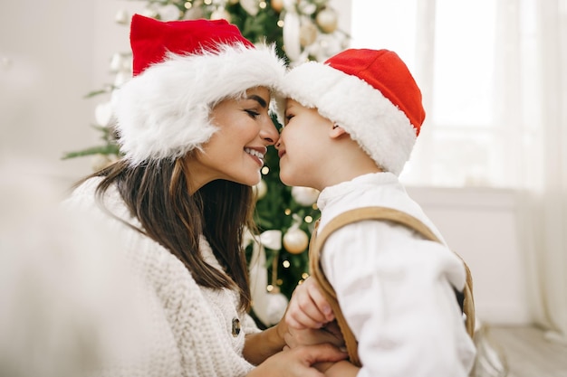 Porträt der glücklichen Mutter und ihres Sohnes feiern Weihnachten im festlich geschmückten Raum