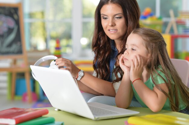 Porträt der glücklichen Mutter und Tochter mit Laptop