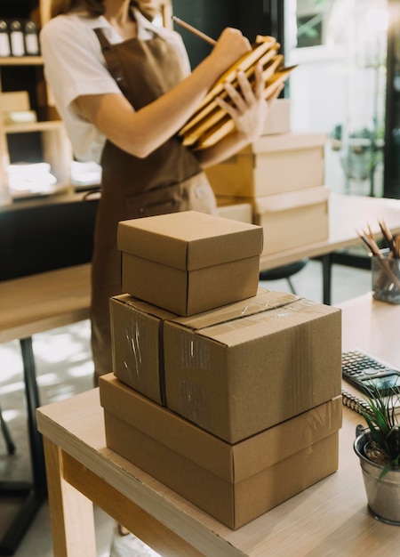 Porträt der Gründung kleiner Unternehmen KMU-Besitzer zwei asiatische Frauen überprüfen Online-Bestellungen Verkauf von Produkten, die mit Boxen arbeiten, freiberufliche Arbeit zu Hause, Büro, KMU-Unternehmen, Online-Kleinmittelunternehmen