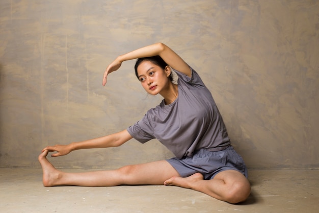 Porträt der herrlichen jungen asiatischen Frau, die Yoga praktiziert