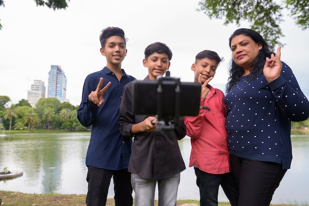 Porträt der indischen Familie, die zusammen am Park entspannt