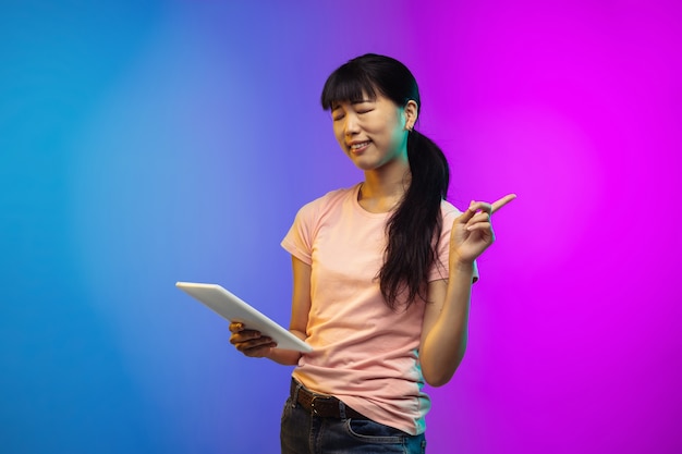 Porträt der jungen asiatischen frau auf steigungsstudio in neon