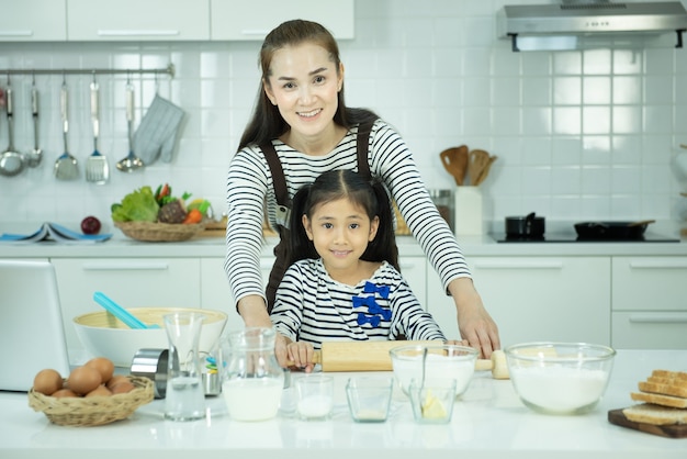 Porträt der jungen asiatischen Mutter und der Tochter, die in der Küche backen und kochen, Aktivität der Familie während der Schulferien.