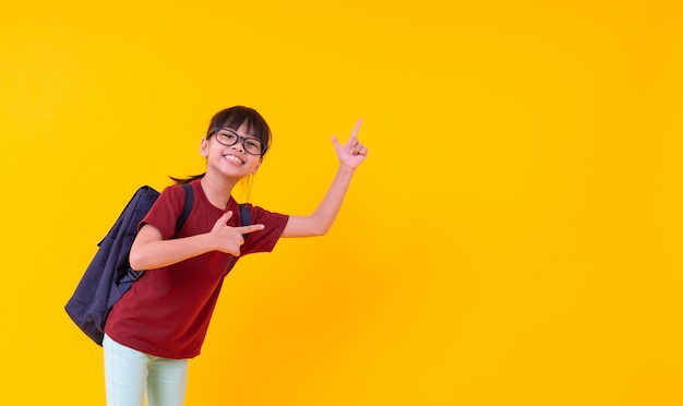 Porträt der jungen asiatischen Studentin, die oben auf Gelb zeigt