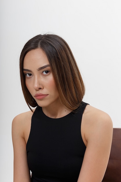 Porträt der jungen attraktiven asiatischen Frau mit langen braunen Haaren in der schwarzen Kleidung