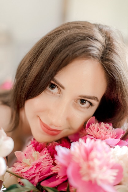 Porträt der jungen Frau, die Blumenstrauß hält